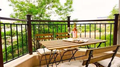 a wooden table and chairs on a balcony at Бяла Виста Бийч Апартментс B - Byala Vista Beach Apartments B in Byala