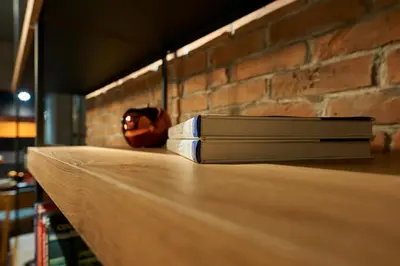 two books sitting on a counter next to a brick wall at Premium Luxury SeaSide Apartment in Burgas City