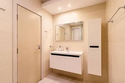 a bathroom with a white sink and a mirror at ЛУКСОЗНА ТРИЕТАЖНА КЪЩА в центъра на Приморско in Primorsko