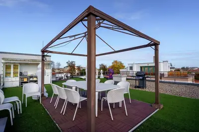 a gazebo with a table and chairs on a patio at ЛУКСОЗНА ТРИЕТАЖНА КЪЩА в центъра на Приморско in Primorsko
