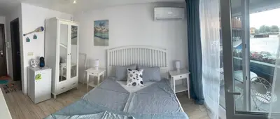 a bedroom with a bed and two tables and a window at PARADISO 'B' 108 Private Cozy Room NESSEBAR in Nesebar