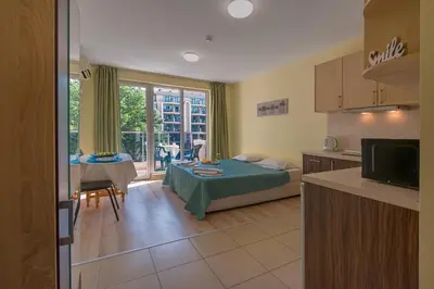a kitchen and living room with a bed and a table at Admiral Plaza Holiday Apartments in Sunny Beach