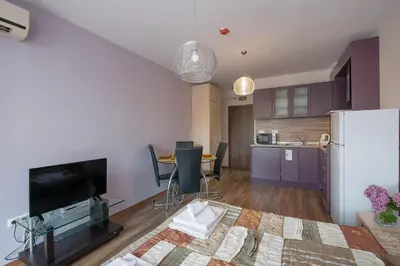 a living room with a tv and a kitchen at Admiral Plaza Holiday Apartments in Sunny Beach