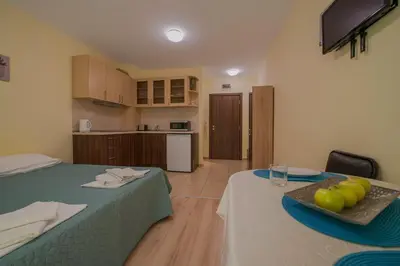 a room with two beds and a table with fruit on it at Admiral Plaza Holiday Apartments in Sunny Beach