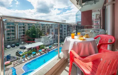 a balcony with a table and a view of a city at Admiral Plaza Holiday Apartments in Sunny Beach