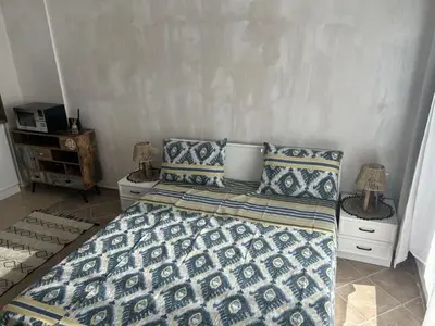a bedroom with a bed with blue and white sheets and pillows at Niya Apartments Kavaci Sozopol in Sozopol