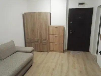 a living room with a couch and wooden cabinets at Apartments Sarafovo in Burgas City