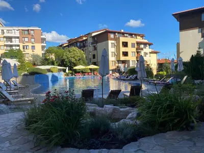 a pool with chairs and umbrellas in a resort at GARDEN OF EDEN B3-2 Private One Bedroom Apartment in Sveti Vlas