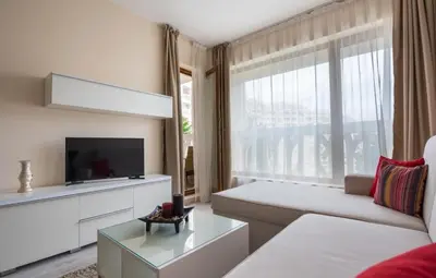 a living room with a couch and a large window at Stoyanov South Bay - Varna in Varna City