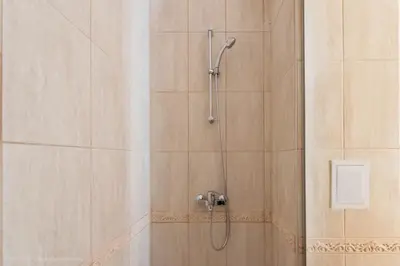 a shower with a shower head in a bathroom at Stoyanov South Bay - Varna in Varna City