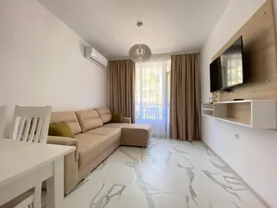 a living room with a couch and a television at The Green Paradise Apartments in Primorsko