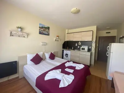 a bedroom with a large bed with two towels on it at SUMMER BREEZE 406 Studio Sunny Beach in Sunny Beach