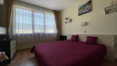 a bedroom with a purple bed and a window at SUMMER BREEZE 406 Studio Sunny Beach in Sunny Beach