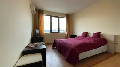 a bedroom with a purple bed and a window at SUMMER BREEZE 406 Studio Sunny Beach in Sunny Beach