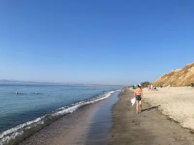 a man walking on a beach near the water at Аpartments Comfort -Marina Cape in Aheloy