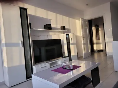 a living room with a tv and a table with glasses at Bayview B32 - Burgas Beach Resort 2 in Burgas City