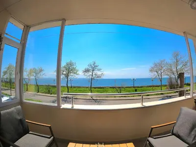 a room with a large window looking out at the ocean at Sunset Yavorov Pomorie in Pomorie