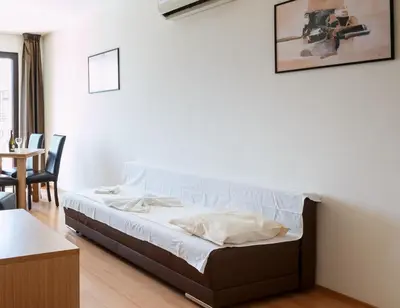 a bed in a room with a table and chairs at Seaside Apartment with 2 Bedrooms for up to 5 Guests in Sunny Beach