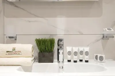 a bathroom sink with a faucet and towels on it at Green Luxury Apartments in Burgas City
