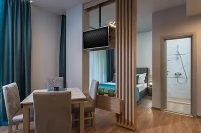 a room with a dining table and a bedroom at Green Luxury Apartments in Burgas City