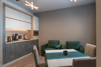a dining room with a table and green chairs at Green Luxury Apartments in Burgas City