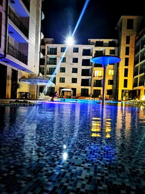 a swimming pool at night with blue lights at Lovely Apartments Amadeus Lux in Sunny Beach