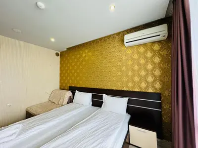 a bedroom with a bed and a yellow wall at PARADISO B 210 Private Sea View Studio NESSEBAR in Nesebar