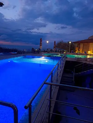 a swimming pool at night with blue illumination at Family Hotel Lalov Egrek in Lozenets