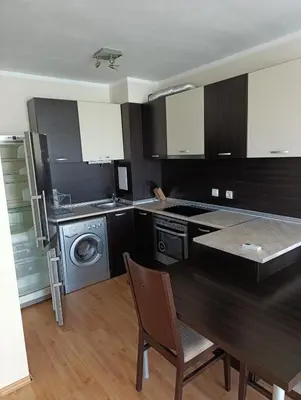 a kitchen with a table and a washing machine at Family Hotel Lalov Egrek in Lozenets