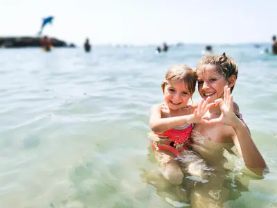 a woman and a child in the water at the beach at Beachfront Apartments by Marty's in Sunny Beach