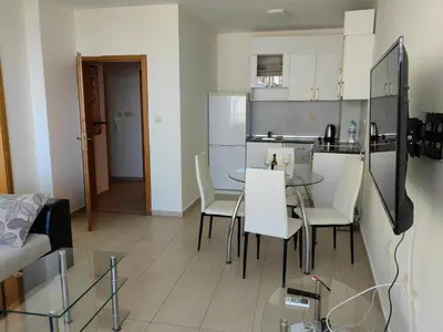 a kitchen and a living room with a table and chairs at Beachfront Apartments by Marty's in Sunny Beach