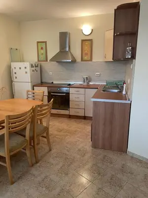 a kitchen with a wooden table and a kitchen with a sink at Rutland SP apartments in Ravda