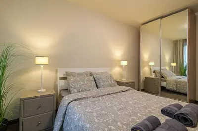 a bedroom with a bed and a large mirror at МareliS Luxe Port Apartment in Varna City