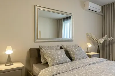 a bedroom with a bed and a mirror on the wall at МareliS Luxe Port Apartment in Varna City