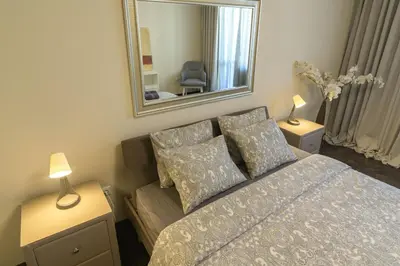 a bedroom with a bed and a mirror and a couch at МareliS Luxe Port Apartment in Varna City