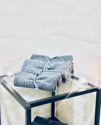 a glass table with two towels on top of it at МareliS Luxe Port Apartment in Varna City
