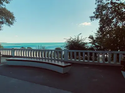 a white bench with a view of the ocean at МareliS Luxe Port Apartment in Varna City