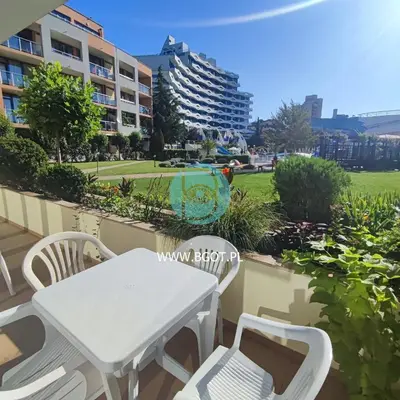 a white table and chairs on the balcony of a building at TRAKIA PLAZA Apartments in Sunny Beach