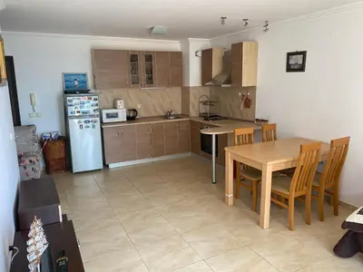 a kitchen with a table and a white refrigerator at Manastira-2 (A-3) in Sveti Vlas