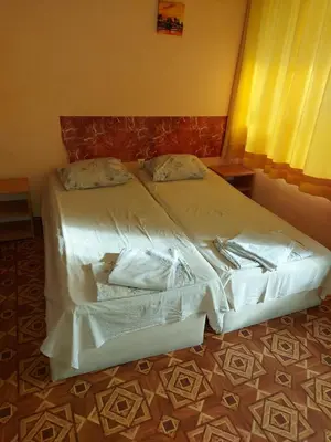 a large bed with white sheets and pillows on it at Studio and 1bedroom apartment Burgas - Economy in Burgas City