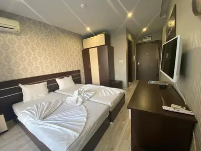 a bedroom with a bed with a desk and a television at PARADISO B 209 Private Sea View Studio NESSEBAR in Nesebar