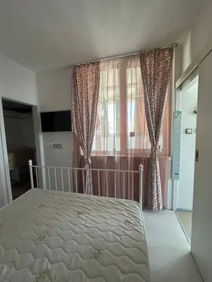 a bedroom with a bed and a window with curtains at Oazis Ravda in Ravda