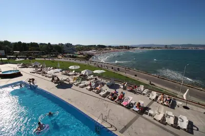 a swimming pool next to a beach with people sitting at PARADISO B 208 Private Sea View Studio NESSEBAR in Nesebar