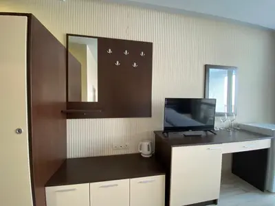 a room with a desk with a tv and a mirror at PARADISO B 208 Private Sea View Studio NESSEBAR in Nesebar