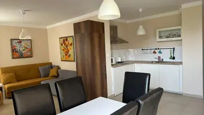 a kitchen and a living room with a table and chairs at Pomorie residence 2-bedroom apartment 300m to the beach in Pomorie