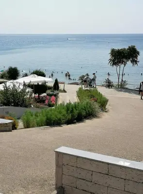 a view of a beach with people in the water at Helios 350m from the beach in Sveti Vlas
