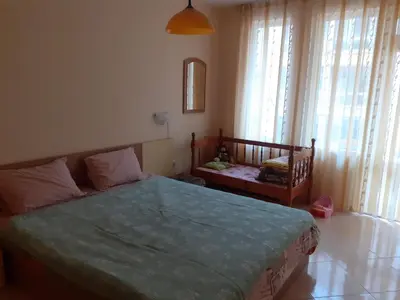 a bedroom with a bed and a window with a crib at Apartments Sea Sounds in Pomorie