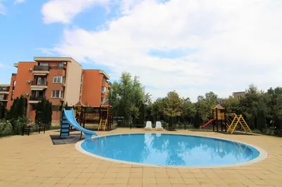 a swimming pool with a slide and a playground at Holiday-Orchid Menada Apartments in Sunny Beach