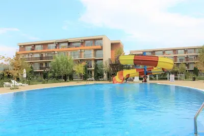 a pool with a water slide in front of a building at Holiday-Orchid Menada Apartments in Sunny Beach