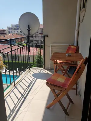 a balcony with a table and a chair on a balcony at Уютно и просторно студио in Ravda